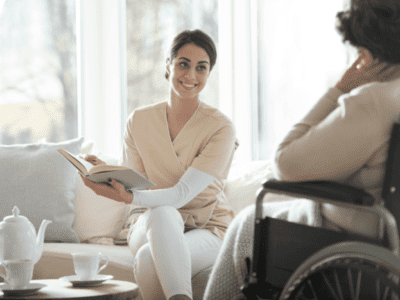 A home care assistant smiling while holding a book