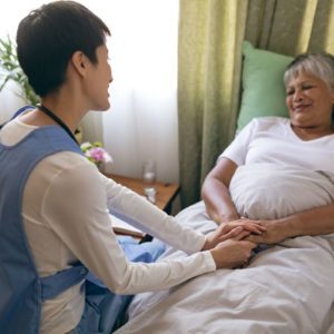 nurse caretaker comforting elderly patient