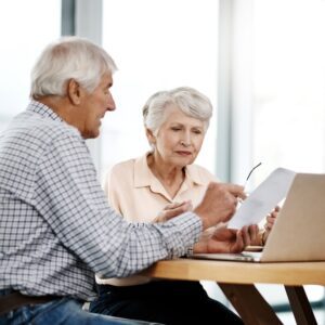 Elderly couple looking over finances at a table.