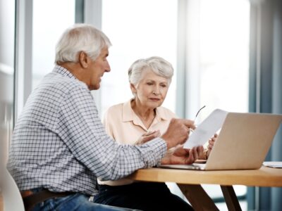 Elderly couple looking over finances at a table.