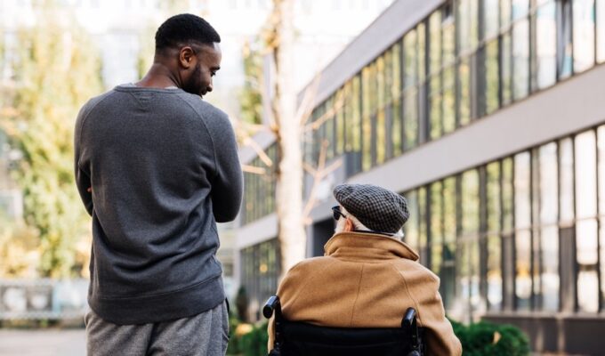 A man in a wheelchair talking to another man